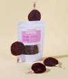 Little Tummy fruit lolly packaging with red lollipops on a beige background
